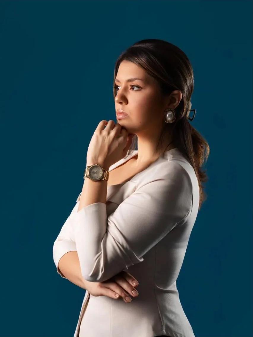 Retrato corporativo de mulher de blusa clara, fundo azul